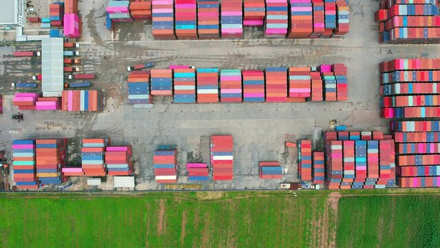 4K : Aerial view from a drone flying over a many cargo containers at distribution center. import and export industry. transportation concept
