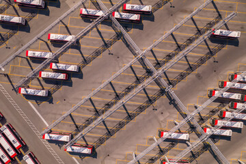 Fototapeta premium The park of new TTC BUSES operated by the Toronto Transit Commission. City public transportation buses parked in the special area. Aerial bird eye view at golden hour and long shadows.