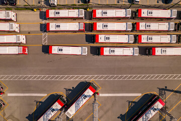 Fototapeta premium The park of new TTC BUSES operated by the Toronto Transit Commission. City public transportation buses parked in the special area. Aerial bird eye view at golden hour and long shadows.