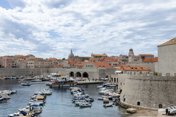 Fototapeta na wymiar Dubrovnik, Croatia - September 21, 2021: Croatian city on the Adriatic Sea with fortress. Panorama view. Boats and ships in harbor in old town. Prominent travel destination. UNESCO World Heritage Site