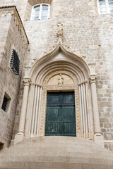 Fototapeta na wymiar Dubrovnik, Croatia - September 21, 2021. The weathered green door marks the entrance to the Dominican Monastery in Old town was listed UNESCO World Heritage. King's Landing, capital Seven Kingdoms
