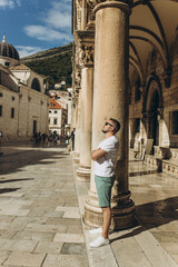Fototapeta na wymiar Dubrovnik, Croatia - September 21, 2021. Man stands at Gothic Rector's palace with Renaissance arched constructions. Old town was listed UNESCO World Heritage. King's Landing, capital Seven Kingdoms