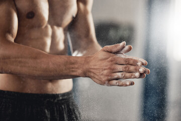 Man with sports chalk powder on his hands in the gym during a fitness training or workout. Closeup...