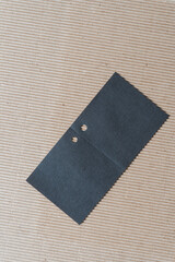 plain brown corrugated paper and unfolded black paper gift tag