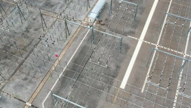 4K : Aerial top view from a drone flying over a high voltage power tower in substation. Electric power industry.
