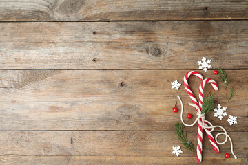 Flat lay composition with candy canes on wooden background, space for text. Winter holidays