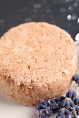 Solid shampoo bar and lavender flowers on white table, closeup