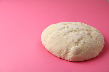 Fototapeta na wymiar Raw dough for pastries on pink background. Space for text