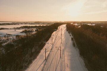 Aerial view of a railroad among pine forests at winter.