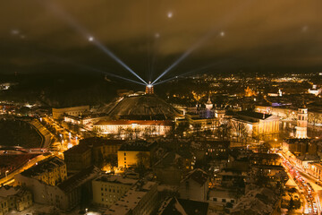 Fototapeta na wymiar Scenic aerial view of Gediminas tower in Vilnius Old Town beautifully illuminated for 699 birthday celebration. Main symbol of Lithuanian capital at winter night.