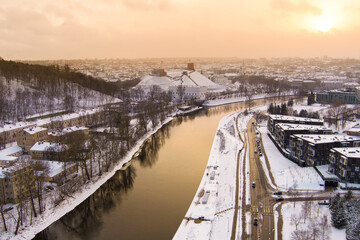 Beautiful Vilnius city panorama in winter with snow covered houses, churches and streets. Aerial sunset view. Winter city scenery in Lithuania.