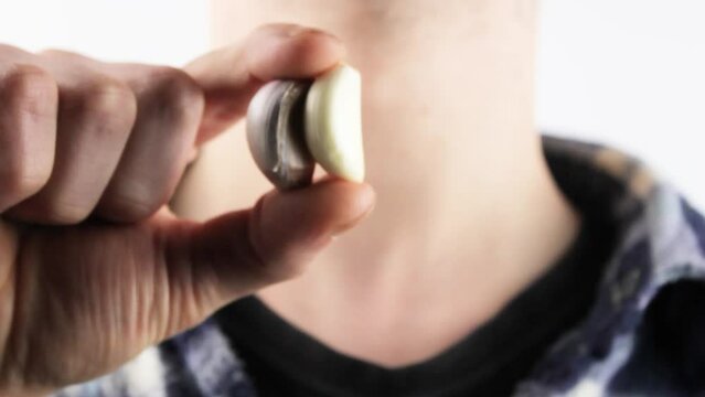 A man holds garlic in his hand. Natural garlic in hand close-up.A clove of garlic.