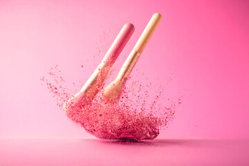 Make up brushes with powder splashes isolated on pink background
