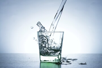 Image of pouring water from a water bottle into a glass