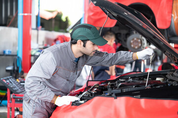 car service, repair, maintenance concept - Arab auto mechanic man or Smith Checking/repair machine at workshop warehouse, technician doing the checklist for repair machine a car in the garage