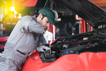 car service, repair, maintenance concept - Arab auto mechanic man or Smith Checking/repair machine at workshop warehouse, technician doing the checklist for repair machine a car in the garage