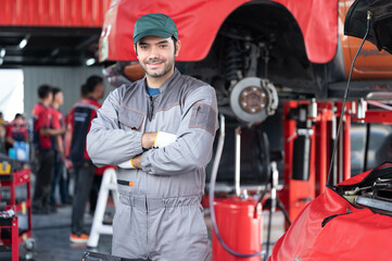 Fototapeta premium car service, repair, maintenance concept - Arab auto mechanic man or Smith stand beside a car at workshop warehouse before start checking a car in the garage for maintenance services