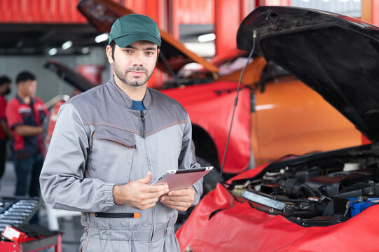 Car Service, Repair, Maintenance Concept - Arab Auto Mechanic Man Or Smith Stand Beside A Car At Workshop Warehouse Before Start Checking A Car In The Garage For Maintenance Services