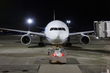 B767-300 plane being pushed back, airport at night