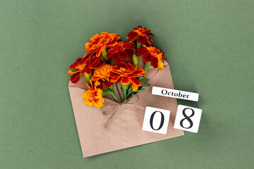 October 8. Bouquet of orange flower in craft envelope and calendar date on green background. Minimal concept Hello fall. Template for your design, greeting card