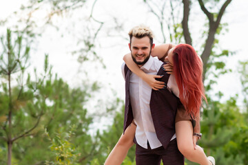 Stylish couple in love walking in the park and hugging. Lovely hipster couple having fun. Youth, love and lifestyle concept