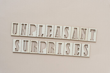 unpleasant surprises - sign with wood type