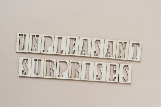 unpleasant surprises - sign with wood type