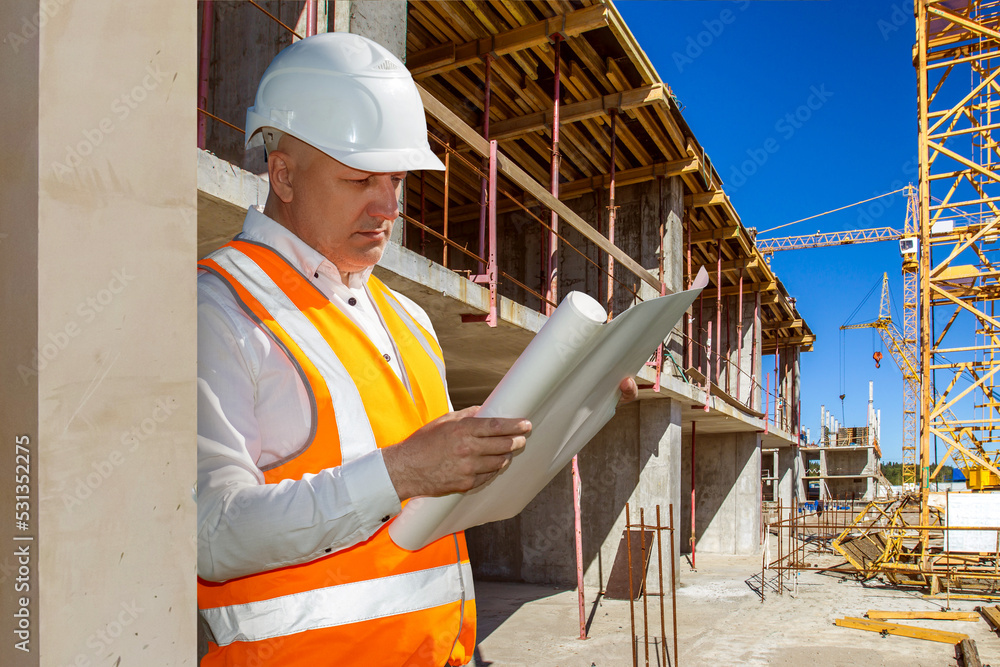 Poster builder at work. man in work uniform near building. builder carefully reads documentation. man at co