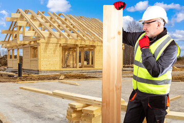 Builder with wooden beam. Builder worker next to cottage under construction. Construction of wooden...