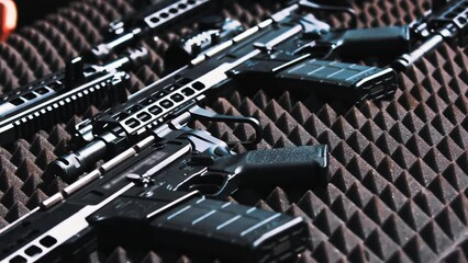 Shiny new professional black firearm put down on special grey foam to avoid scratching and breaking. Closeup outdoor shot. High quality 4k footage
