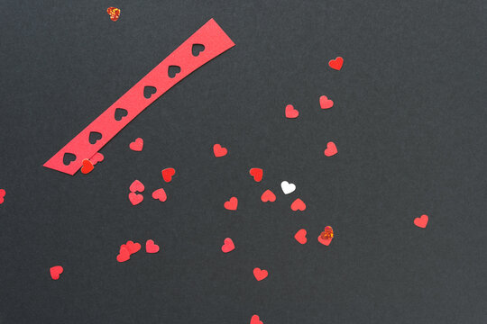 Red And White Paper Heart Shaped Confetti On Black Paper