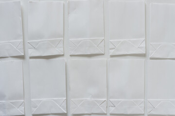 two rows of white mini paper bags on white paper