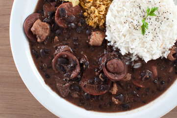 Feijoada leve com arroz branco e fatia de laranja além da farofa e couve presentes na culinária brasileira 