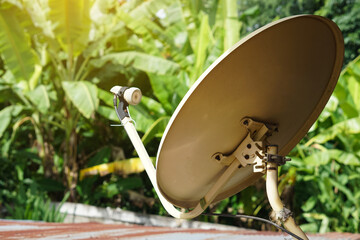 Vintage satellite receiver dish on the roof in rural house. Concept : Terrestrial TV receivers. TV antenna. Device technology for receiving television broadcasting   