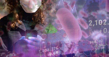 Covid-19 cells and stock market data processing against woman wearing face mask using smartphone