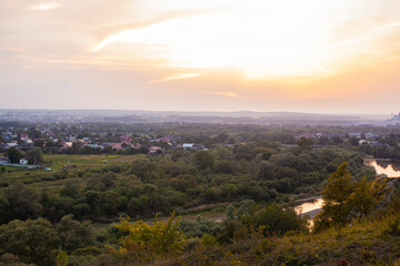 Panoramic view of the city of Ivano-Frankivsk at evening. View from mountain hill on sunset over Ivano Frankivsk city in Ukraine. Landscape with hills and river.