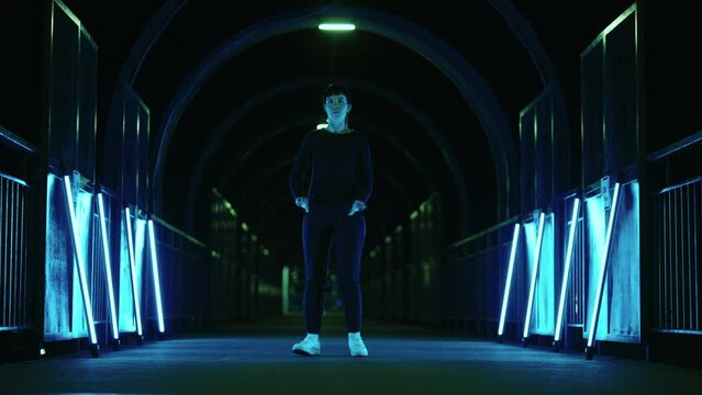 popping dance flashmob in underground corridor, woman is dancing like robot, blue lights in tunnel