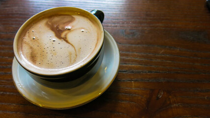 hot chocolate served in a cup. wooden table.
