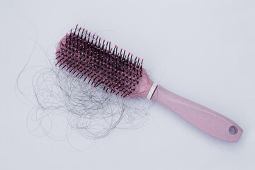 Pink comb brush with hair loss. Concept : hair loss problems , disbalance hormones , stress or worried, cancer chemo that can effect with hair health. Women health problem       