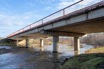 Concrete bridge across a small river. Close-up.
