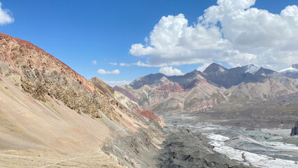 Panorama of colorful rocky mountains, snow-capped peaks and hills of Kyrgyzstan. The amazing nature of the Pamirs.
