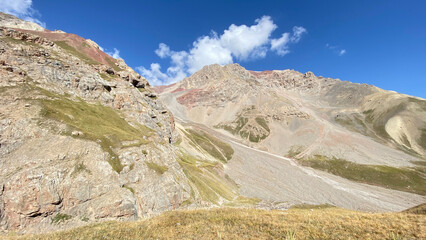 Colored rocky mountains, green slopes and hills of Kyrgyzstan. Beautiful summer mountain landscape.
