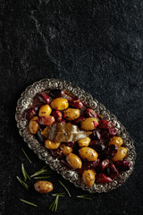 Spicy olives on a black stone table.