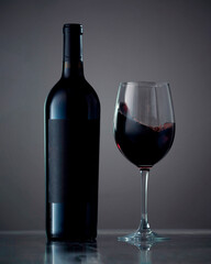 Bottle and glass with wine. Wine culture concept. Copy space, dark background, mock up. isolated on black background