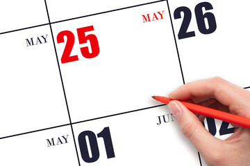 A hand holding a red pen and pointing on the calendar date May 25. Red calendar date, copy space,...