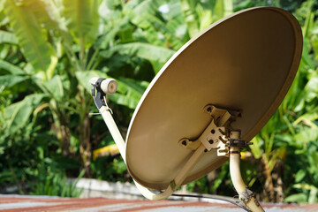 Vintage satellite receiver dish on the roof in rural house. Concept : Terrestrial TV receivers. TV antenna. Device technology for receiving television broadcasting  