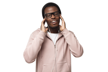 Portrait of happy young black man in pink hoodie, holding earphones with both hands; listening music wiht closed eyes