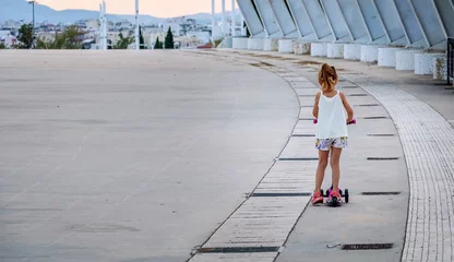 Fotobehang Child having fun and riding a scooter © Rogerio Silva