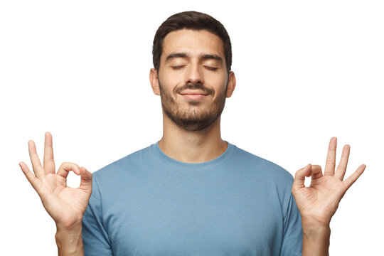 Happy smiling man standing with closed eyes, having relaxation while meditating. Yoga and meditation. .