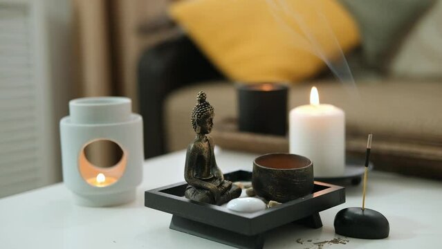 Vintage bronze statuette with candlestick made of copper. Statue of Buddha, incense sticks and burning candle. Aromatherapy, home fragrance. Concept of home relaxation and anti stress, zen buddhism.